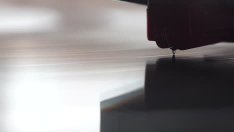 crystal gramophone needle on spinning vinyl record, close up