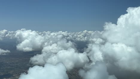 Flying-across-a-sky-with-some-tiny-white-cumulus-in-a-hot-summer-day