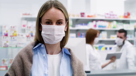 frau mit medizinischer maske in der apotheke