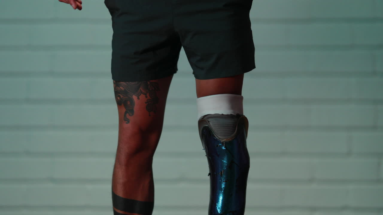 el hombre atlético se abrocha en soportes de piernas protésicas y está listo para la actividad deportiva