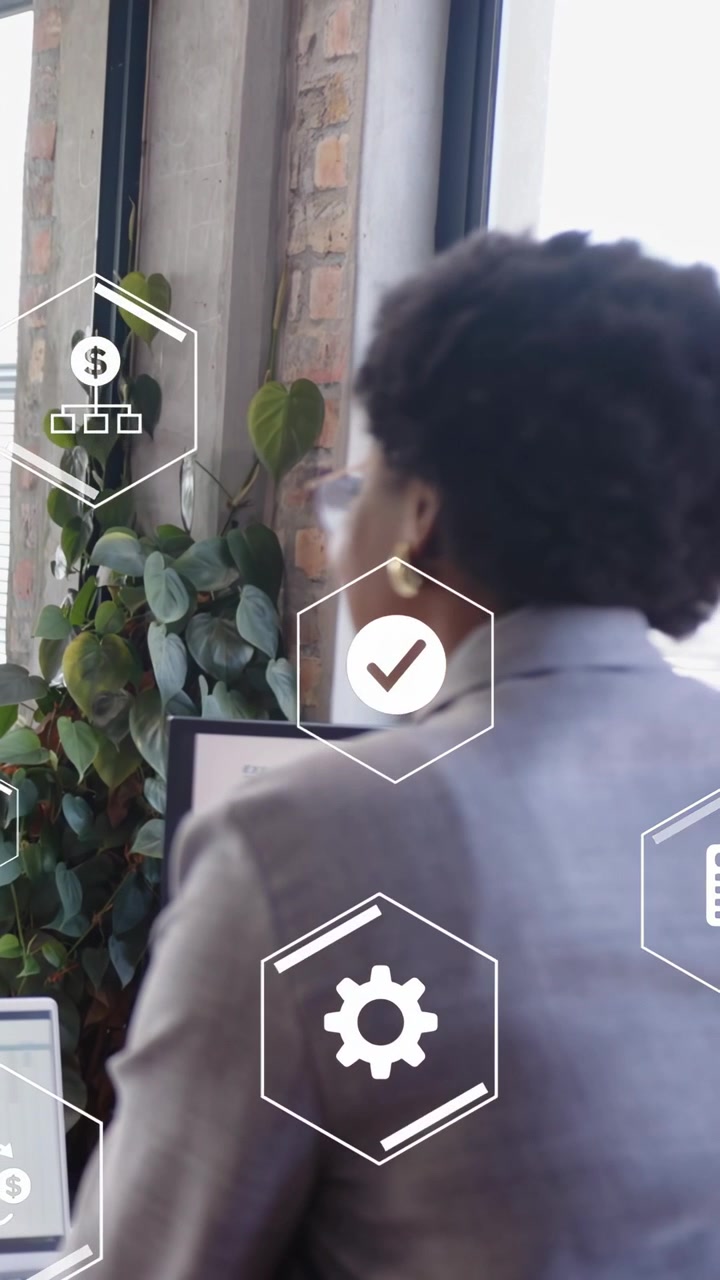 Vertical video: Woman manager glancing at monitors, finance icons animating over laptop charts