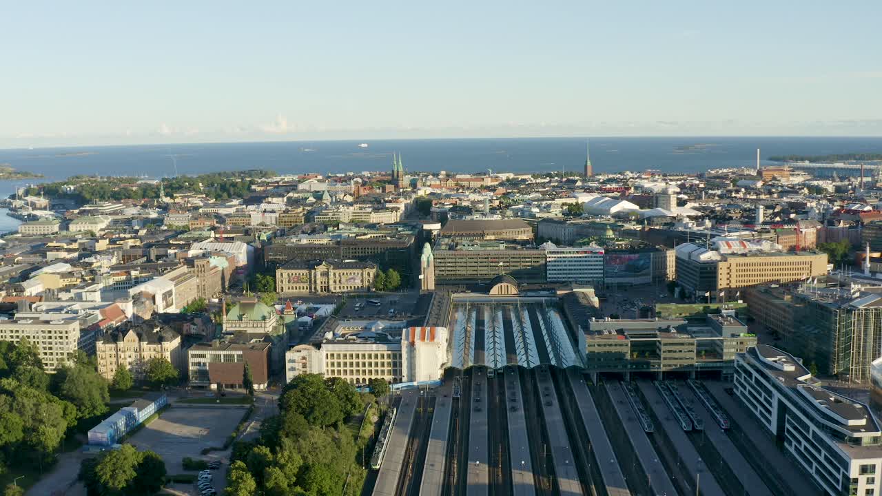 Lenta panoramica aerea di grandi edifici a Helsinki, Finlandia, con l'oceano in lontananza