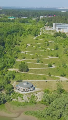 picturesque landscape with green hill hairpin curves and round pavilion on sunny autumn day bird eye view