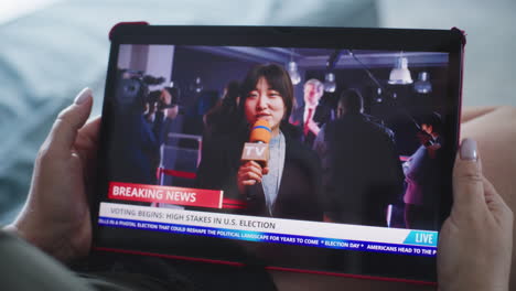 woman watching us election news on a tablet