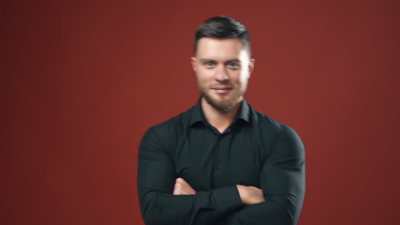 Elegant male model in studio. Confident businessman standing with his hands folded at his chest