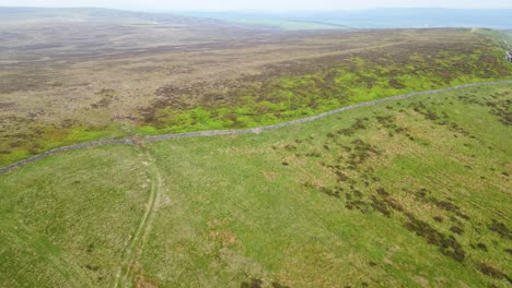 An-aerial-shot-over-calm-slopes-where-a-solo-traveller-leads-his-path-on-the-edge-of-the-hill