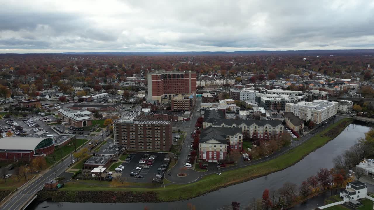 Aerial view of Rahway NJ showing residential homes, waterways, winding roads, tree lines, and nearby buildings captured from drone perspective on a cloudy day