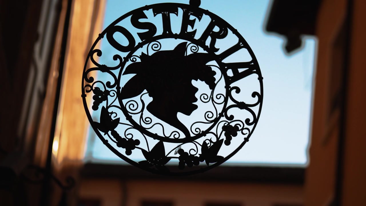 Insegna stradale esterna in ferro battuto per un ristorante e osteria tradizionale italiano con profilo della testa di Bacco.