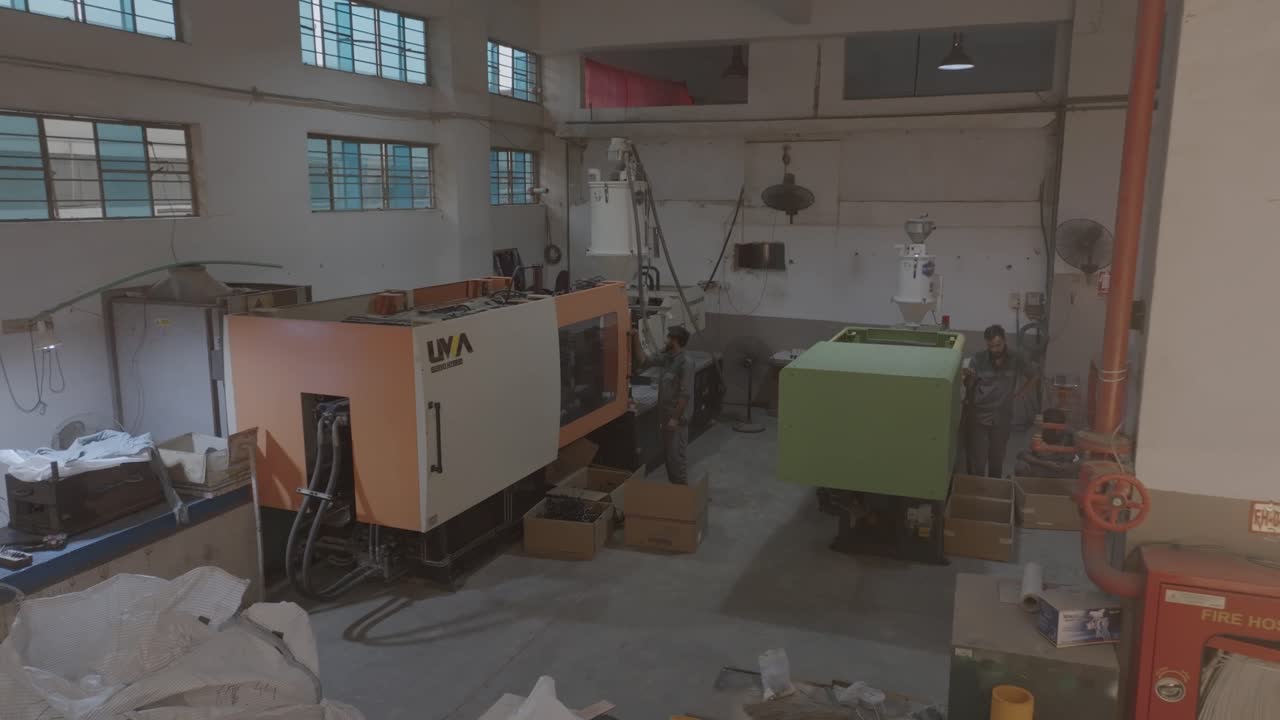 Aerial view of various machines at PVC Pipe Making Factory in Karachi, Pakistan. Workers checking the machines.