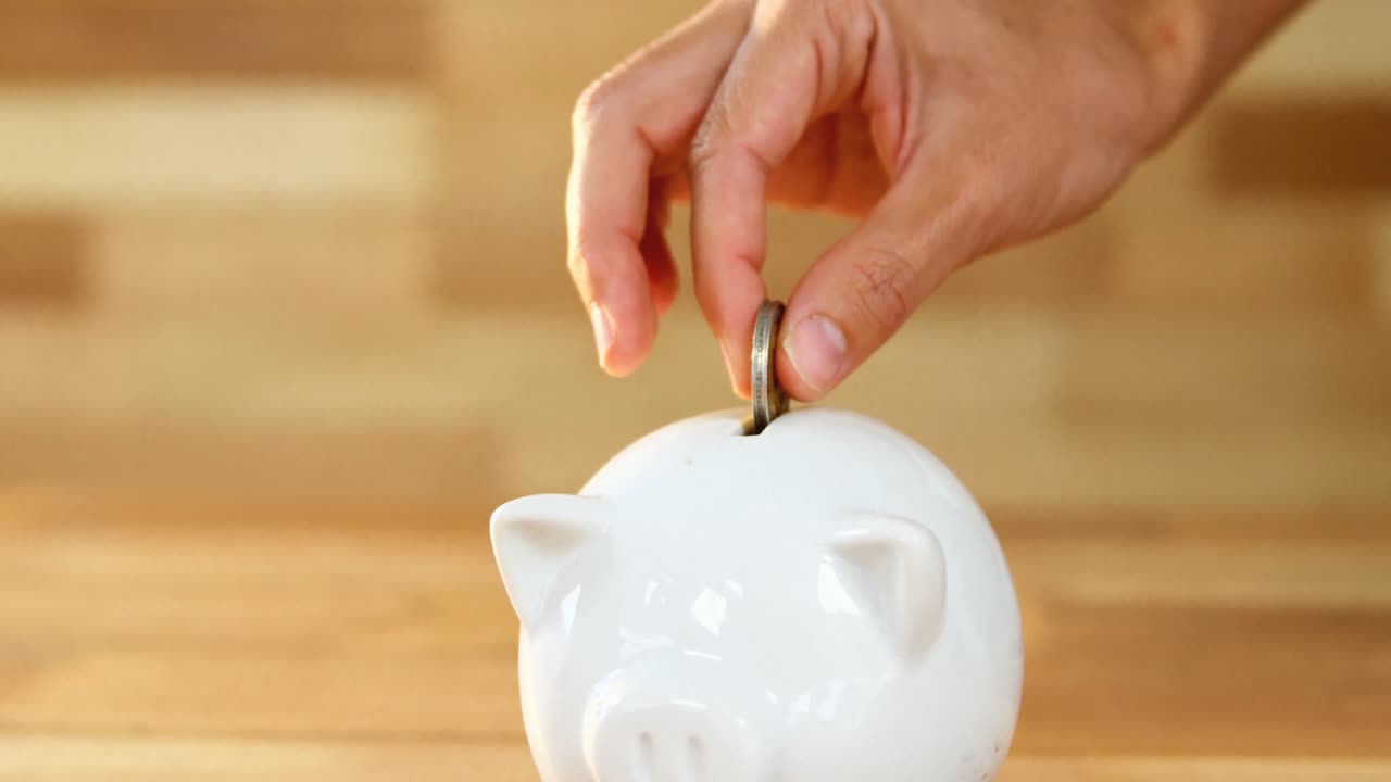 Woman putting coin in piggy bank