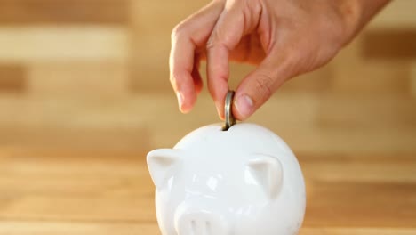 mujer poniendo monedas en la hucha