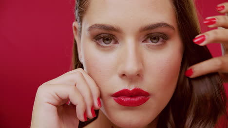 retrato en primer plano de una mujer con lápiz labial y uñas rojas