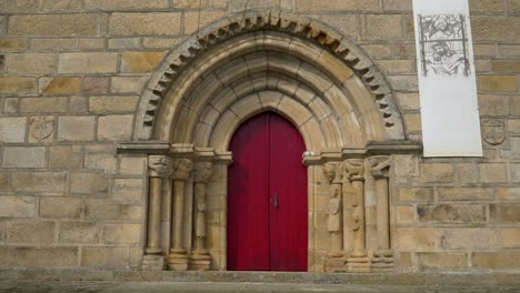 ancient stone church with red door and gothic arch