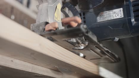 a wooden board is sawn with a circular saw