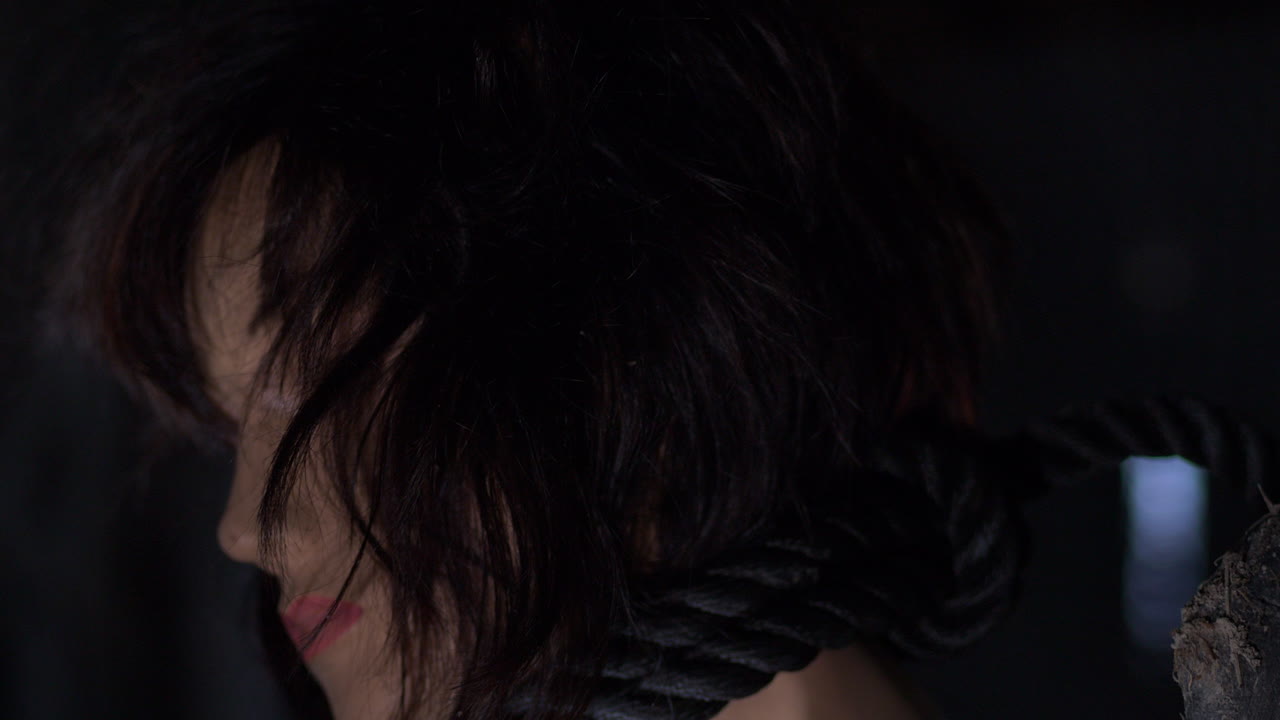 primer plano muñeca de aspecto auténtico que cuelga la soga, cabello castaño femenino, tiro estático