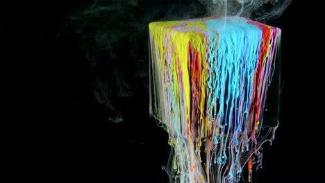 multicolored ink paint slowly flows from the cube underwater