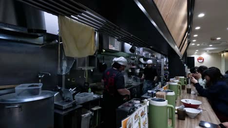 chefs preparing ramen for customers in a kitchen