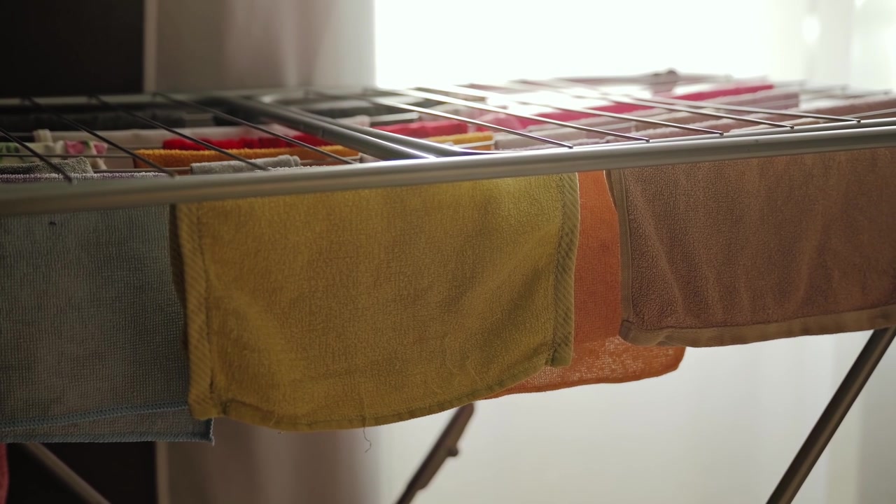 Soft cotton towels air dry indoors beside bright window, reflecting cozy home..