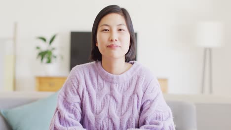 portrait of happy asian woman having video call in living room