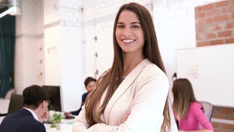 mujer sonriente en la oficina con compañeros de trabajo