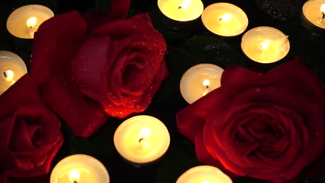 rosas y velas sobre un fondo negro.