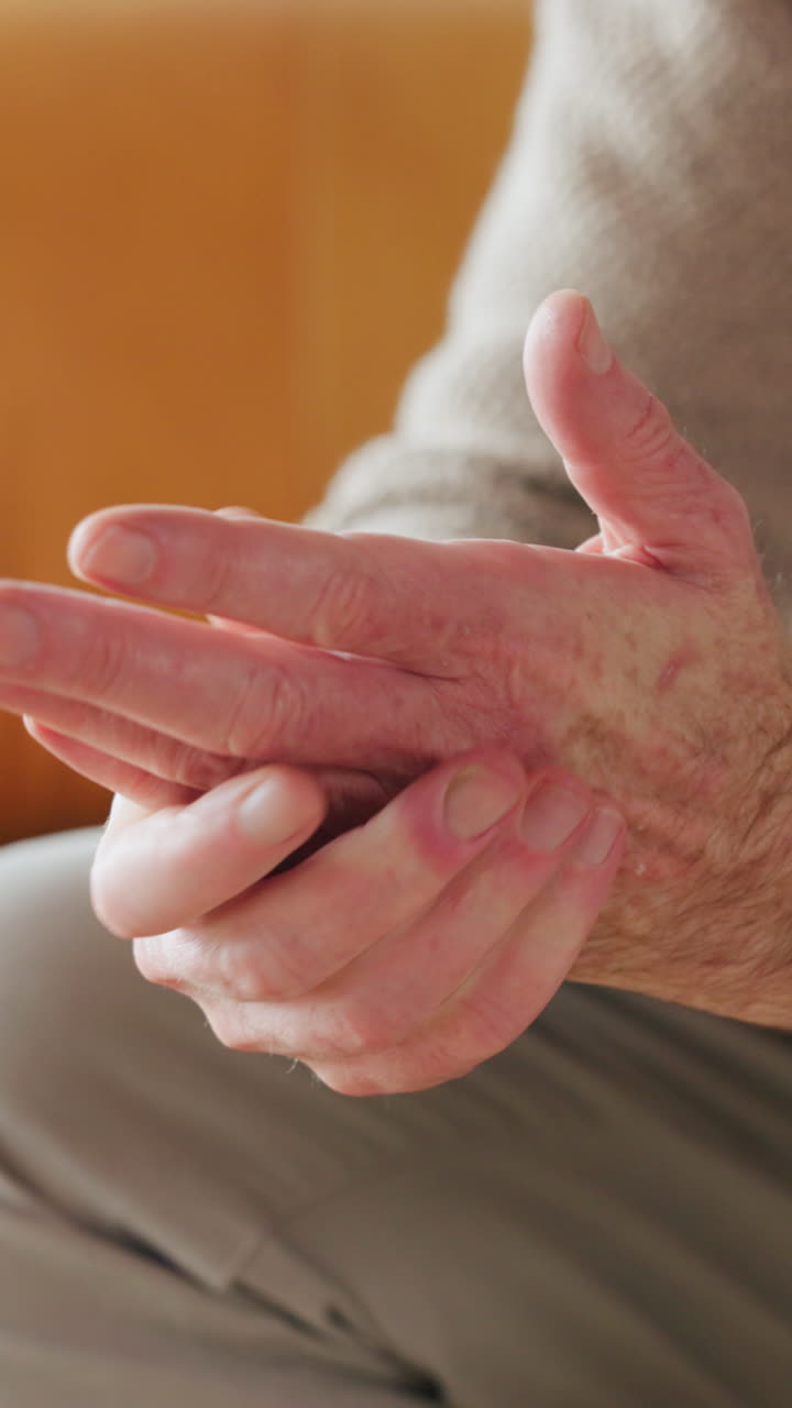 Primo piano di una persona anziana che si sfrega le mani