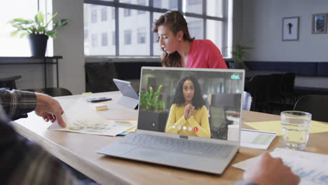 Caucasian-businessman-on-laptop-video-call-with-african-american-female-colleague-on-screen