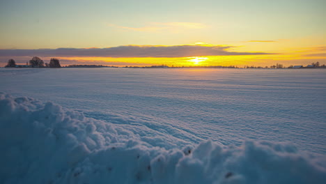 Schneehaufen-Im-Vordergrund-Und-Schneefeld-Mit-Aufgehender-Sonne-Im-Hintergrund