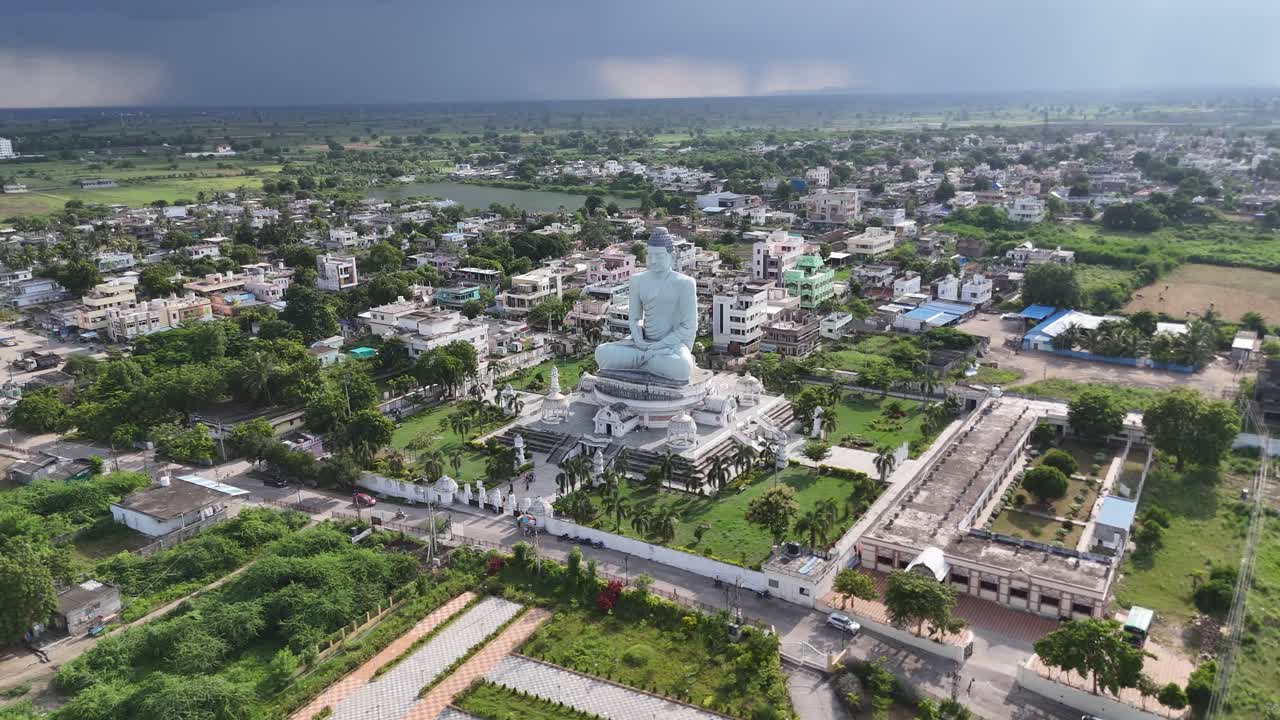 Aerial drone of Buddha temple near a river with cloudy background.