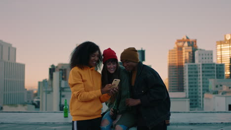 young african american woman taking photo of  friends posing on rooftop at sunset enjoying hanging out together drinking alcohol sharing friendship in urban city skyline