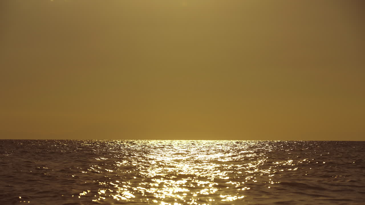바다 위에서 황금빛 해가 지는 것