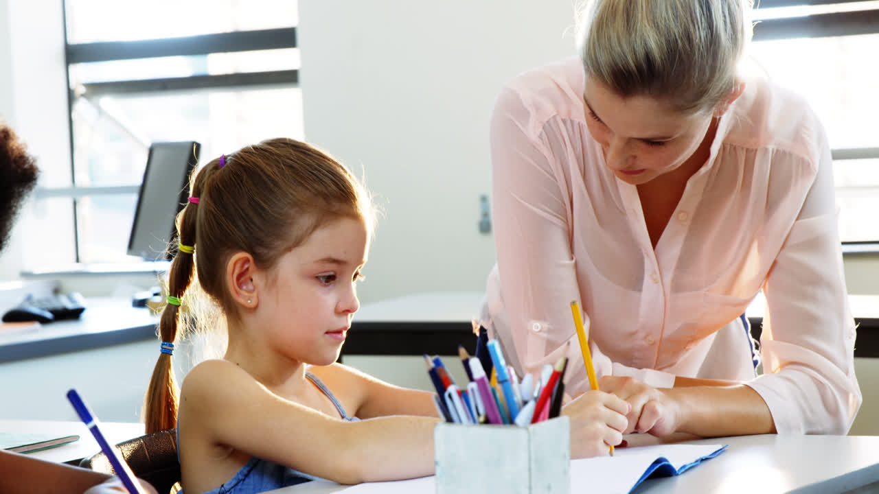 maestro ayudando a los niños con sus tareas en el aula