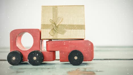 Red-toy-car-with-a-present-combined-with-falling-snow