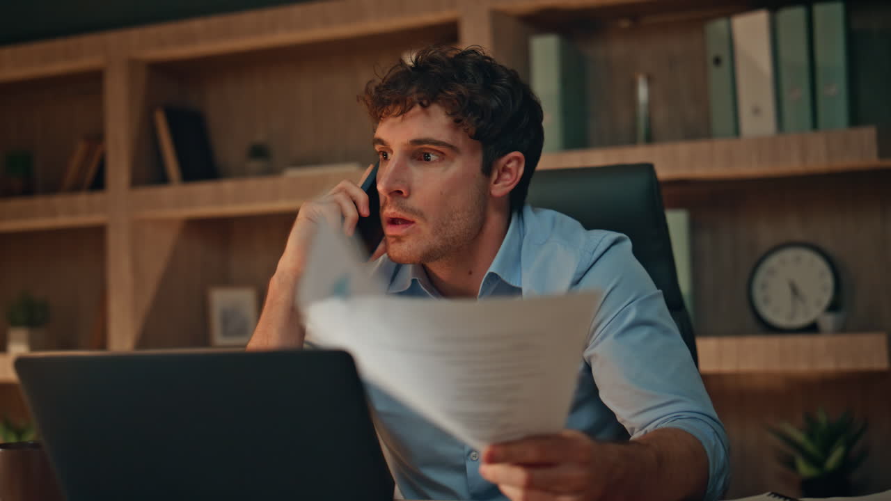 Mad executive calling smartphone holding documents at night workplace close up.