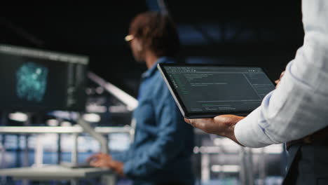 close up of data center admin using tablet to reviewing machine learning code