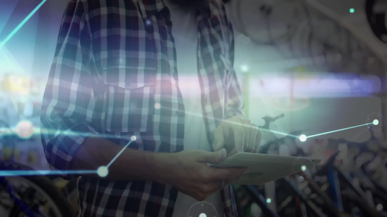 In bicycle shop, man using tablet with animation of digital network connections