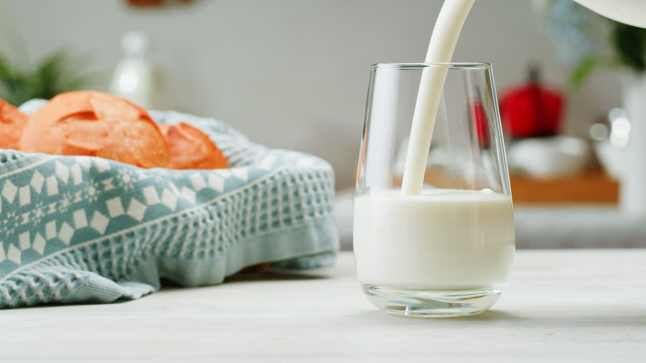 vertiendo leche en un vaso con pan en el fondo