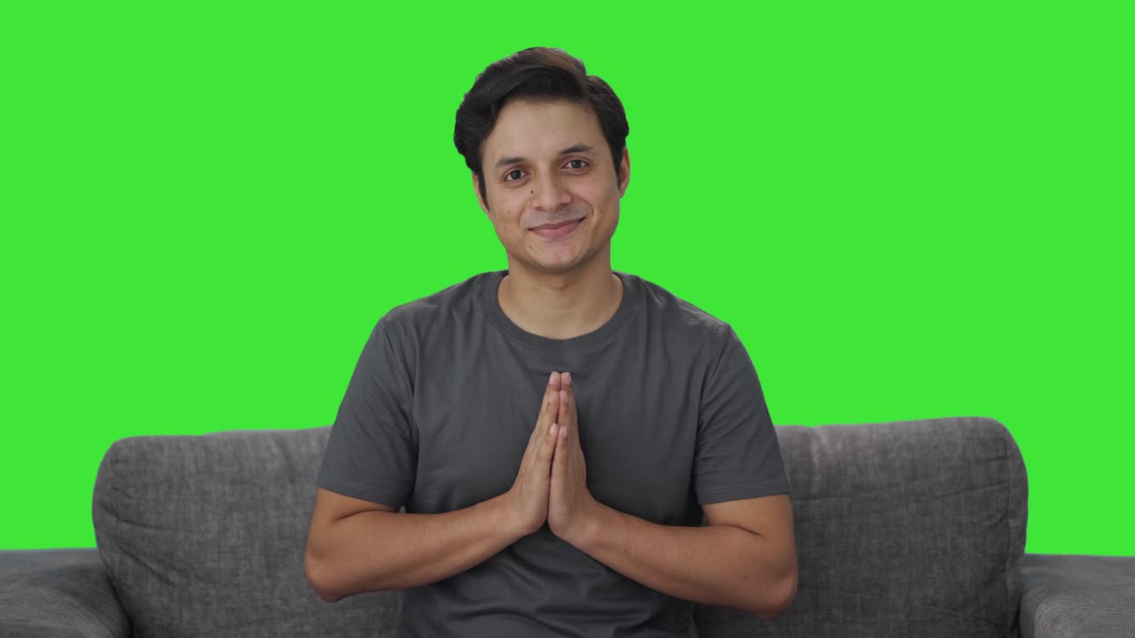 Happy Indian man doing Namaste Green screen