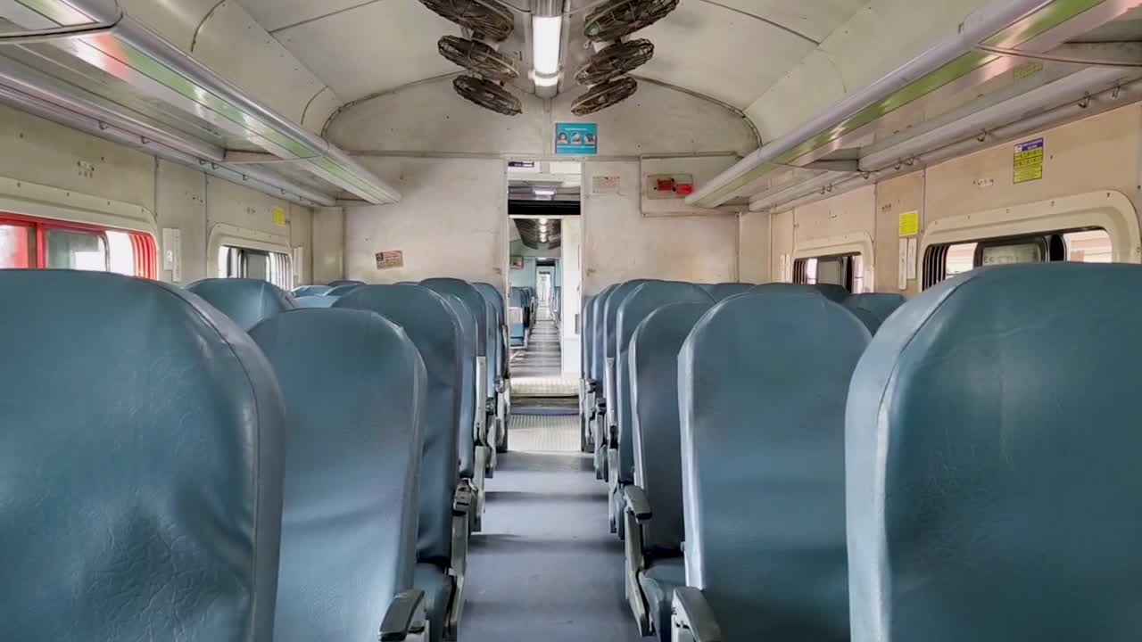 View from inside an Indian local train, blue-colored chairs that highlight train's interior design.
