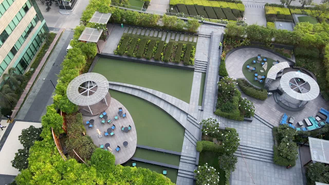 Sweeping drone shots of a sleek business park in Gurgaon, Haryana—glass skyscrapers, landscaped greenery, and urban infrastructure reflecting India’s growing global corporate presence