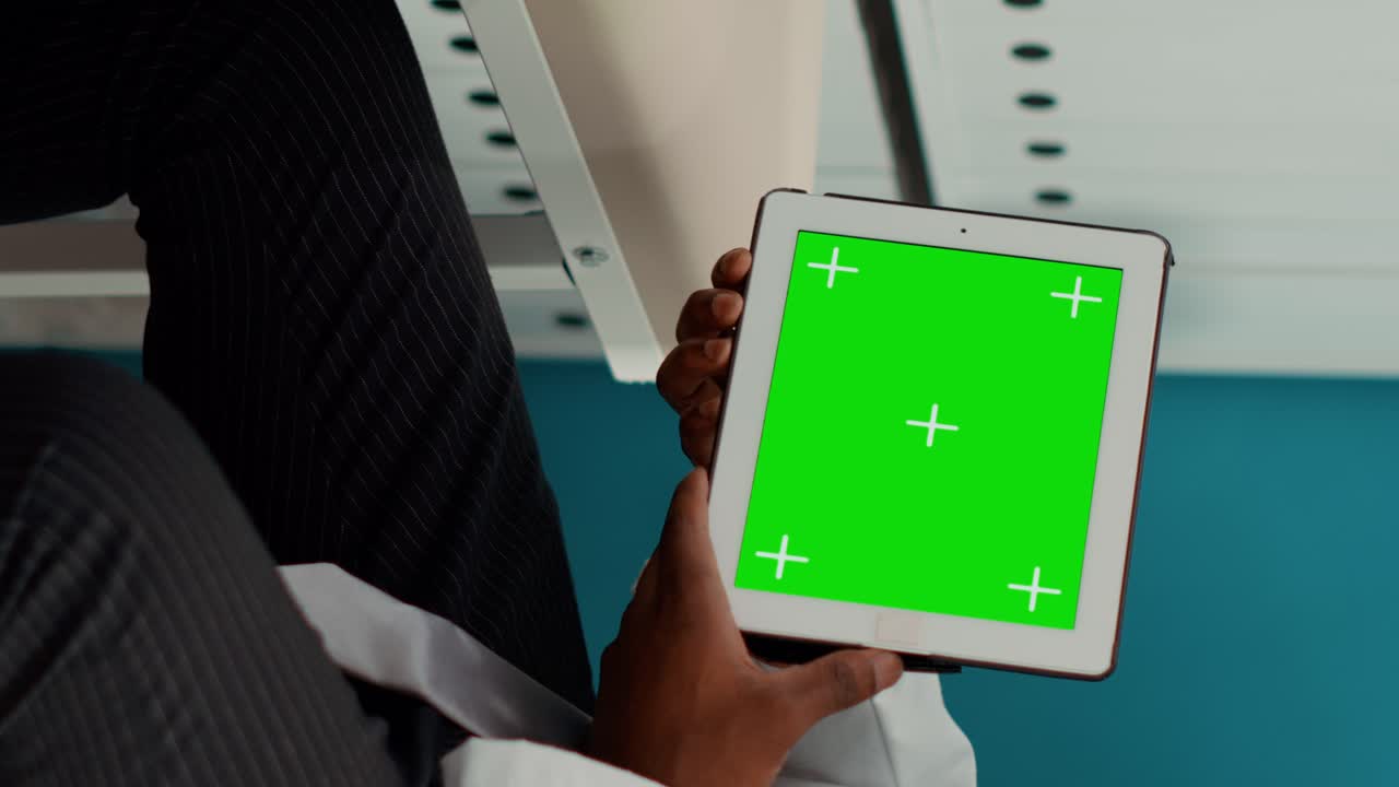 Specialist holding digital tablet with horizontal greenscreen