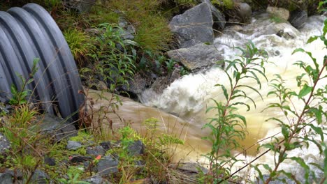 el agua de lluvia marrón sucia sale de la tubería de drenaje durante las inundaciones en noruega - primer plano