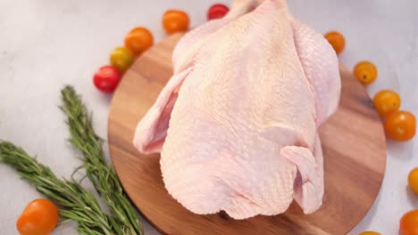 raw chicken on wooden board with vegetables