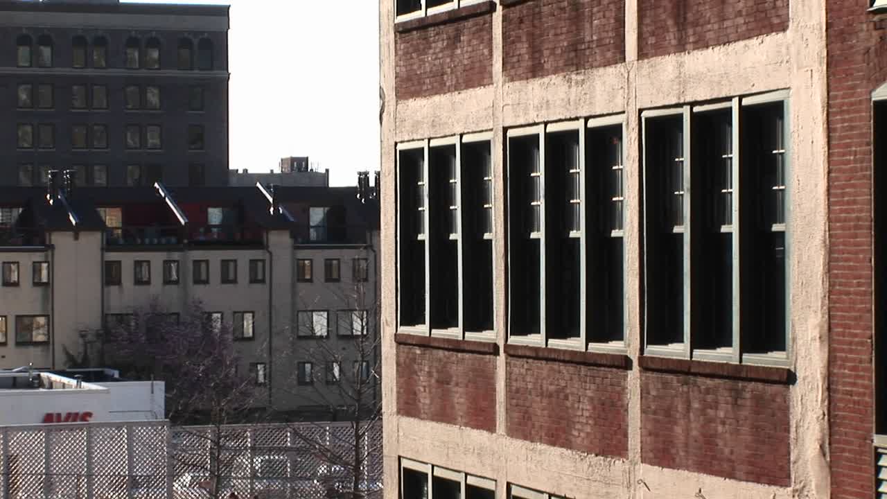 카메라는 보다 현대적인 타운하우스 옆에 위치한 오래된 학교 건물을 확대합니다.