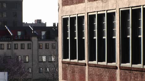 the camera zooms in on old school building located next to more modern townhouses