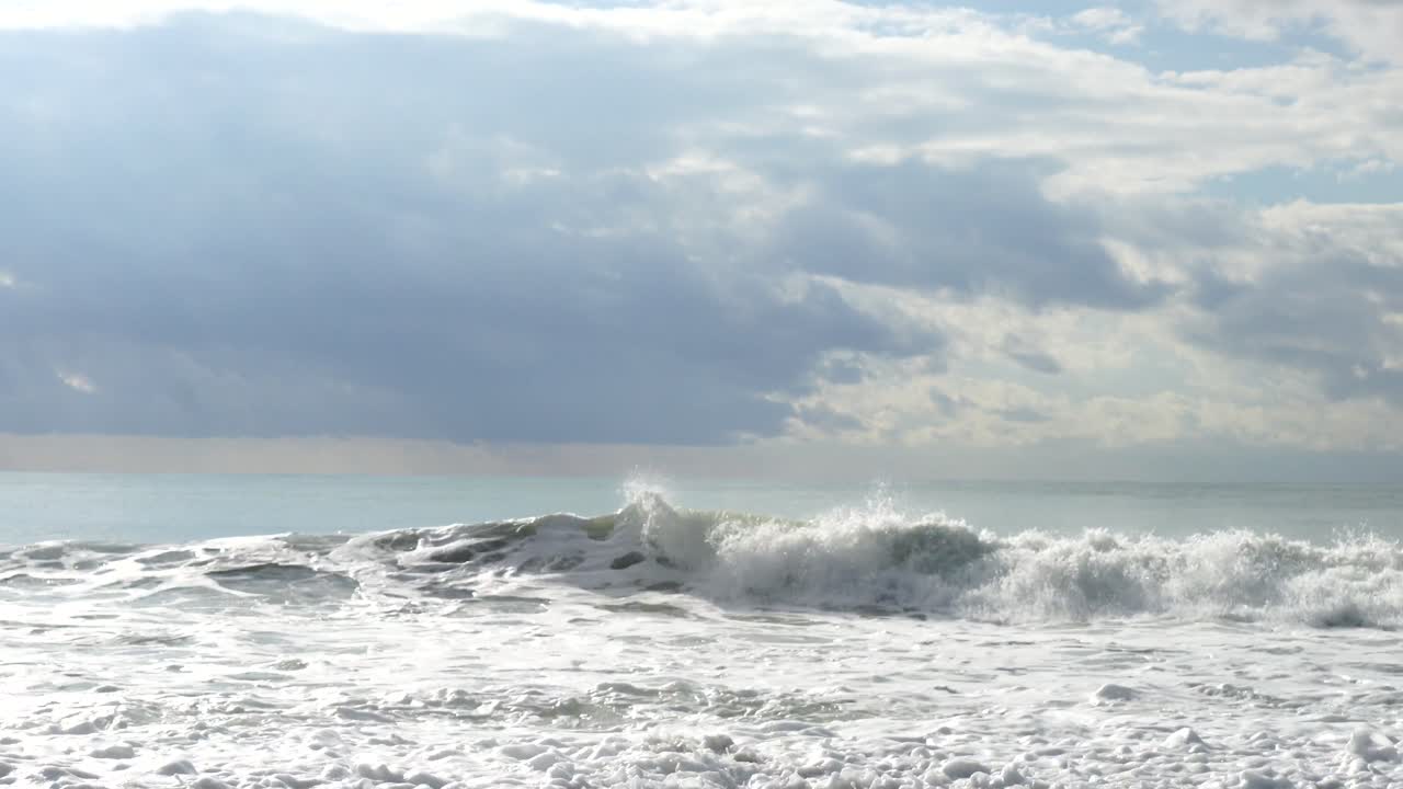 Dramatic Ocean Waves Crashing on the Shore Under a Cloudy Sky