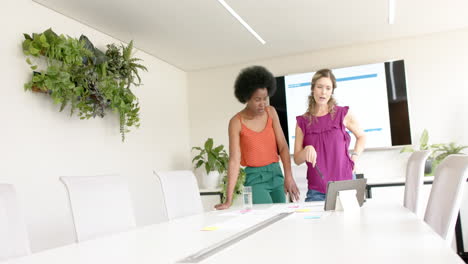 diverse female creative colleagues brainstorming in meeting in board room, slow motion
