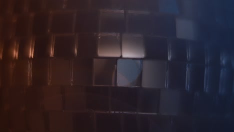 cerca de la pelota de discoteca azul azulado y naranja con llamaradas de lente brillando sobre ella