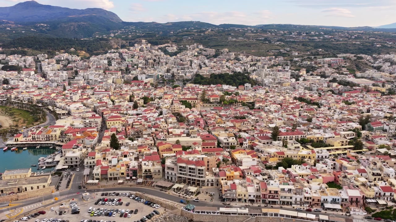 Vista aérea de drone do centro histórico e do minarete da Mesquita Neratze elevando-se acima dos telhados de telha vermelha, Rethymno, Grécia