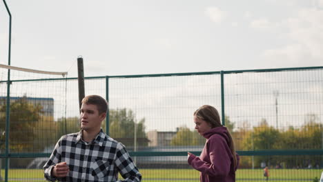 coach guiding his student in jogging on outdoor court, with clear focus on their movement and greenery in the background, showcasing outdoor physical activity and sports training